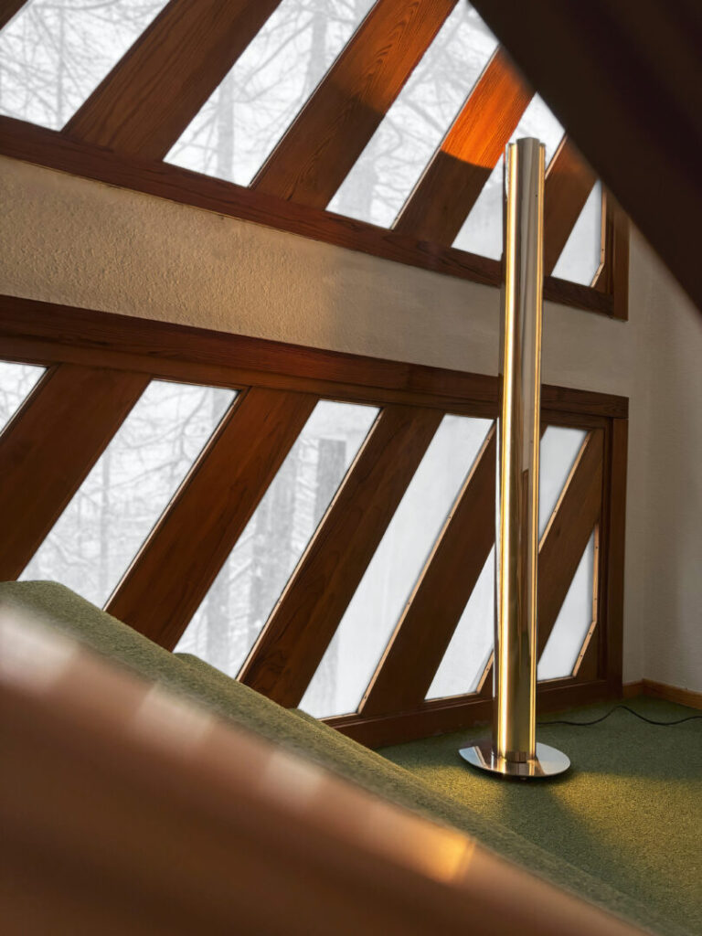 lampada da terra in metallo in un'interno con finestre